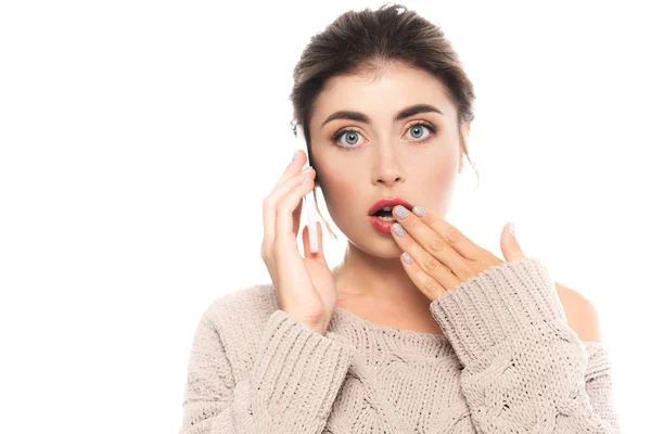Shocked woman covering mouth with hand while talking on smartphone isolated on white — Stock Photo
