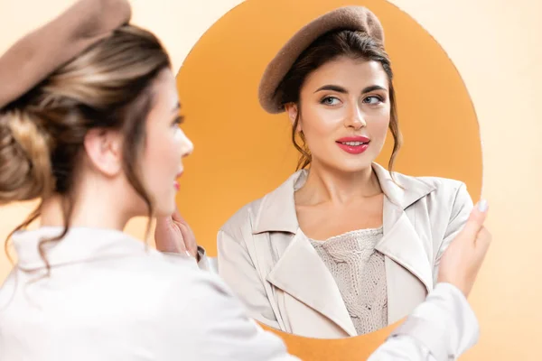 Selektiver Fokus der trendigen Frau im Herbst-Outfit, die im Spiegel auf Pfirsich blickt — Stockfoto