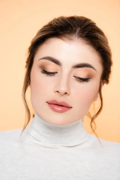 Young woman in turtleneck posing isolated on peach — Stock Photo