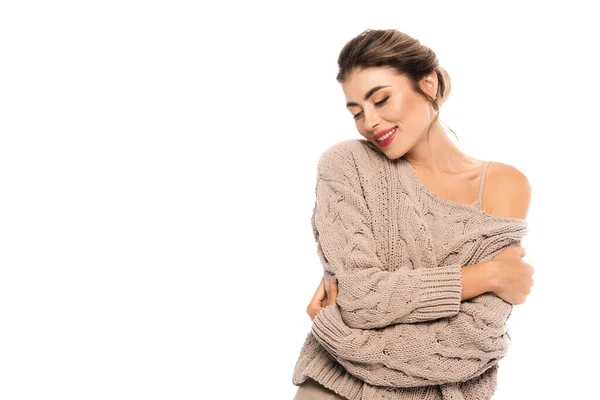 Joyful woman in openwork sweater hugging herself with closed eyes isolated on white — Stock Photo