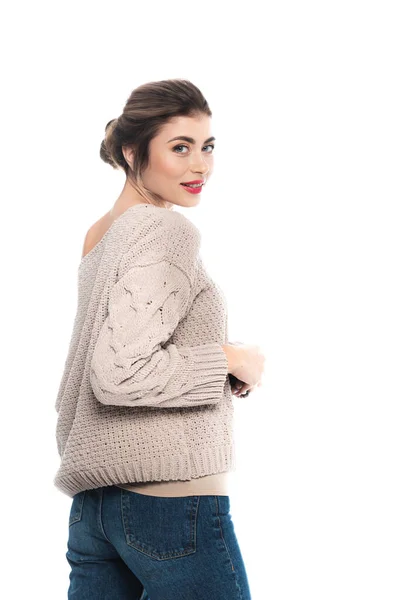 Sensual woman in stylish sweater and jeans looking at camera isolated on white — Stock Photo