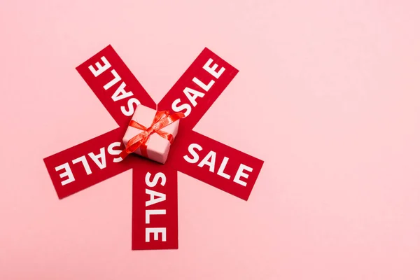 Vista dall'alto del piccolo regalo vicino ai tag con scritte in vendita su rosa, concetto di venerdì nero — Foto stock