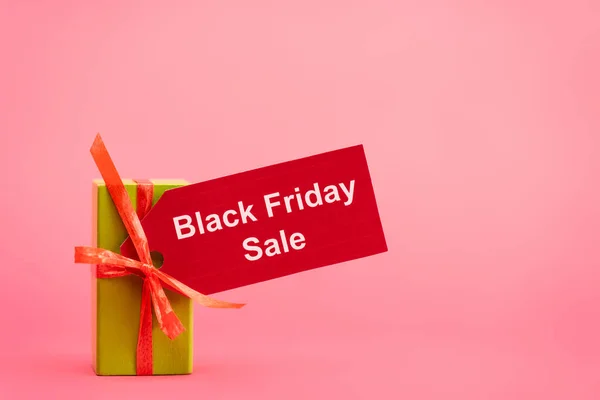 Gift box with black friday sale tag on pink — Stock Photo