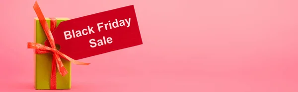 Panoramic shot of gift box with black friday sale tag on pink — Stock Photo