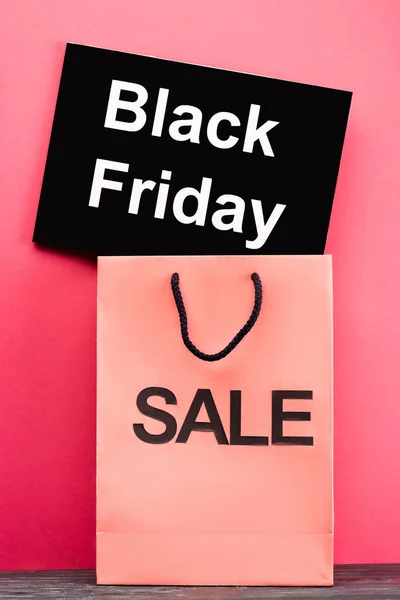 Plakat mit schwarzem Freitag-Schriftzug neben Einkaufstasche auf rosa — Stockfoto