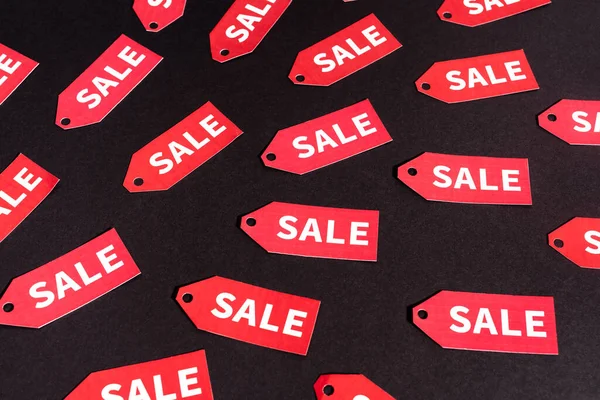 Etiquetas rojas con letras de venta sobre fondo negro - foto de stock