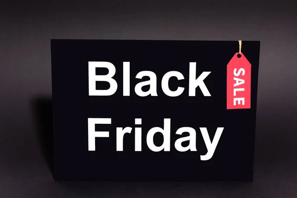 Placard with black friday lettering and sale tag on dark background — Stock Photo