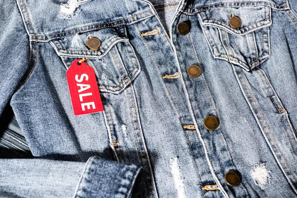 Close-up de etiqueta venda vermelha na jaqueta jeans azul, conceito de sexta-feira preta — Fotografia de Stock