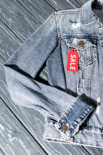 Top view of red sale tag on blue denim jacket, black friday concept — Stock Photo