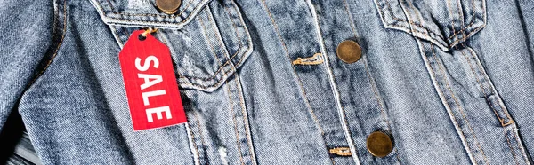 Close-up de etiqueta de venda vermelha na jaqueta de ganga azul, cultura panorâmica — Fotografia de Stock