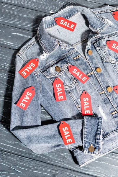 Draufsicht auf rote Verkaufsetiketten an blauer Jeansjacke, Black-Friday-Konzept — Stockfoto