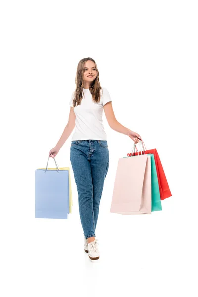 Freudige junge Frau hält Einkaufstüten in der Hand und schaut isoliert auf weißem Grund weg — Stockfoto