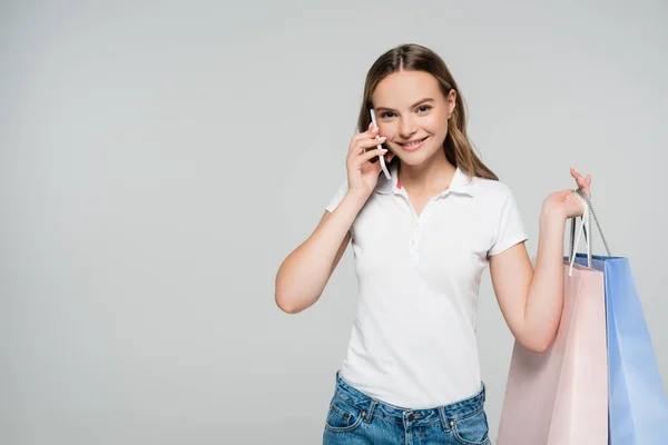 Giovane donna gioiosa che parla su smartphone isolato su grigio — Foto stock