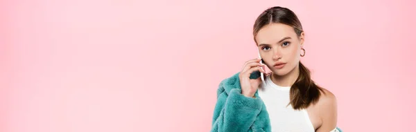 Panoramaaufnahme einer jungen Frau, die auf einem Smartphone spricht, isoliert auf rosa — Stockfoto