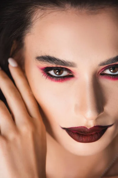 Nahaufnahme einer jungen Frau mit dunklem Make-up, die in die Kamera blickt — Stockfoto