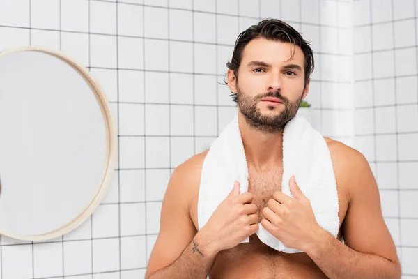 Bearded uomo senza maglietta con capelli bagnati toccando asciugamano in bagno — Foto stock