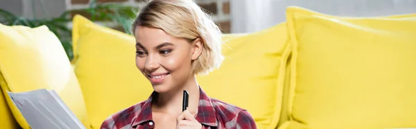 Young blonde woman looking through documents, horizontal banner — Foto stock