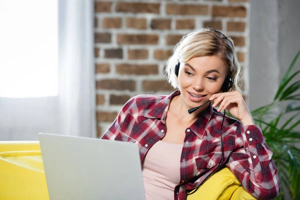 Young blonde woman having webinar and talking on microphone — Stock Photo