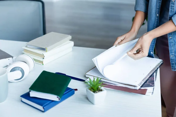 Vista ritagliata di donna che gira pagine di notebook — Foto stock