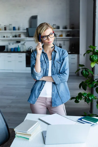 Mulher loira pensativa em óculos trabalhando em casa — Fotografia de Stock