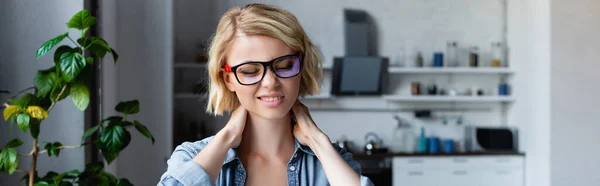 Young blonde woman in eyeglasses kneading neck, horizontal banner — Fotografia de Stock