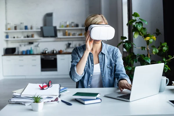 Mujer rubia en auriculares vr trabajando desde casa - foto de stock