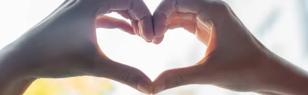 Ausgeschnittene Ansicht einer Frau mit herzförmigem Zeichen mit Händen, horizontalem Banner — Stockfoto