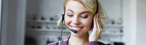 Young blonde woman in checkered shirt and headphones, horizontal banner — Stock Photo