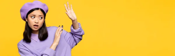 Asian woman in beret showing no gesture with hands isolated on yellow, banner — Stock Photo