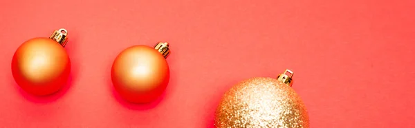 Draufsicht auf glänzende Christbaumkugeln auf rotem Hintergrund, Banner — Stockfoto