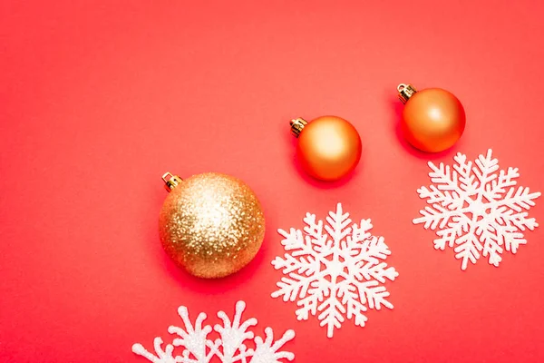 Vue de dessus des flocons de neige, boules sur fond rouge — Photo de stock