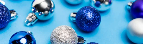Brillantes adornos de Navidad sobre fondo azul, bandera - foto de stock