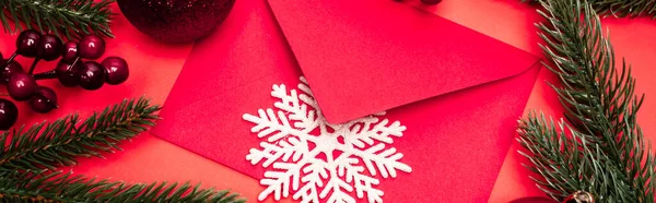 Vista superior de la decoración de Navidad y sobre sobre fondo rojo, bandera - foto de stock