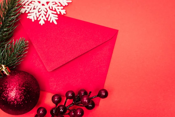 Vista superior da decoração de Natal e envelope no fundo vermelho — Fotografia de Stock