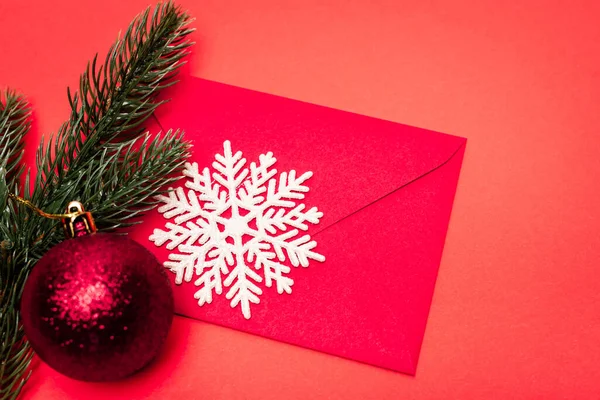 Top view of Christmas decoration and envelope on red background — Stock Photo