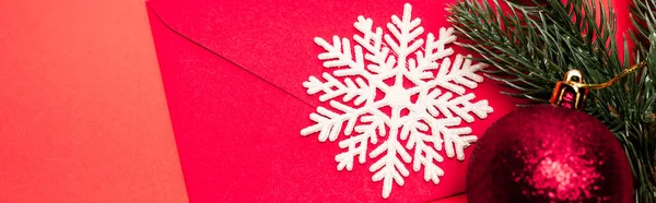 Vista superior de la decoración de Navidad y sobre sobre fondo rojo, bandera - foto de stock