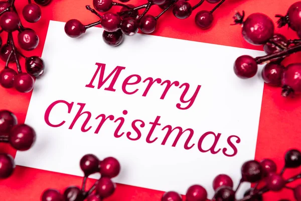 Frohe Weihnachten Karte und Beeren auf rotem Hintergrund — Stockfoto