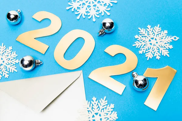 Новорічна прикраса, конверт і номери 2021 року на синьому фоні — стокове фото