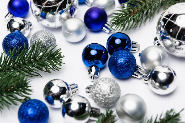 Azul, plata decoración de Navidad y ramas de abeto sobre fondo blanco - foto de stock