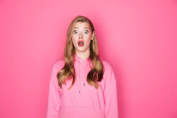 Schockierte schöne Frau mit offenem Mund auf rosa Hintergrund — Stockfoto
