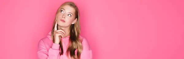 Nachdenklich schöne junge Frau in Kapuzenpulli auf rosa Hintergrund, Banner — Stockfoto