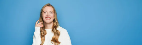 Glücklich blonde schöne Frau im Pullover isoliert auf blauem Hintergrund, Banner — Stockfoto