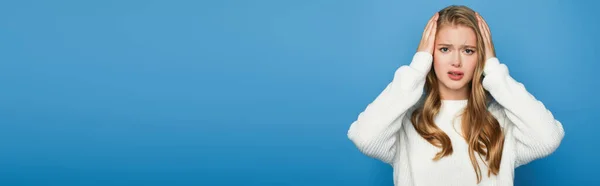Mulher bonita loira em suéter com dor de cabeça isolada no fundo azul, banner — Fotografia de Stock