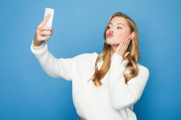 Blondine schöne Frau macht Selfie mit Entengesicht isoliert auf blauem Hintergrund — Stockfoto