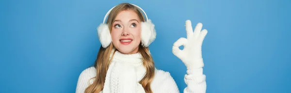 Sourire belle femme en tenue blanche d'hiver montrant ok isolé sur bleu, bannière — Photo de stock