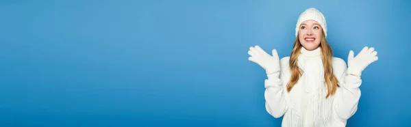 Sonriente hermosa mujer en invierno traje blanco aislado en azul, bandera - foto de stock