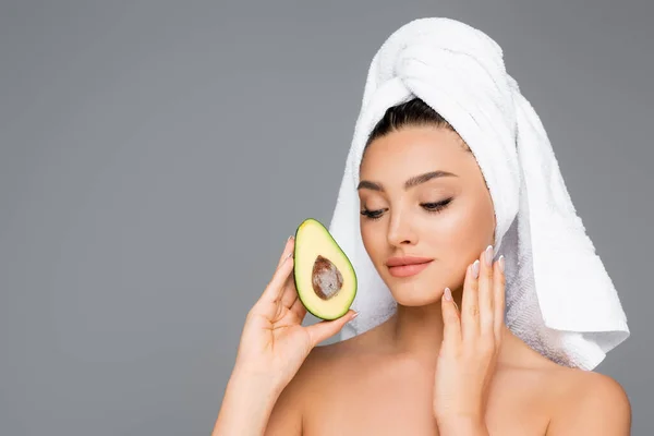 Donna con asciugamano sulla testa e avocado isolato su grigio — Foto stock