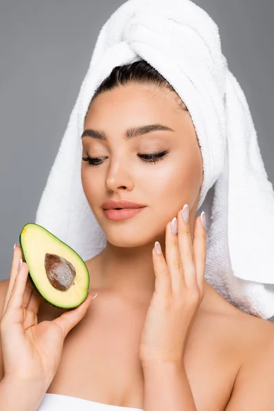 Donna con asciugamano sulla testa e avocado isolato su grigio — Foto stock