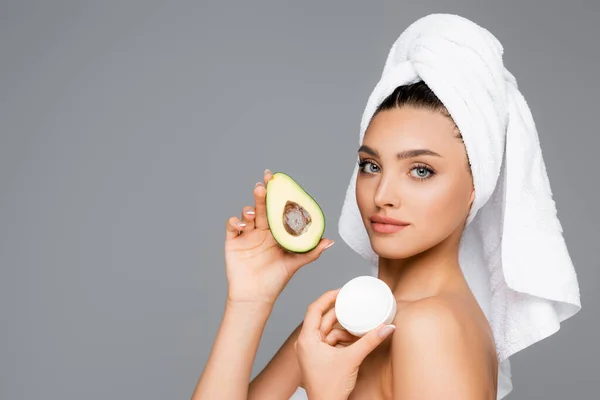 Женщина с авокадо и косметическим кремом изолированы на сером — стоковое фото
