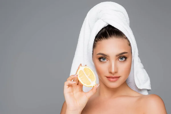 Жінка з рушником на голові і лимоном ізольована на сірому — стокове фото